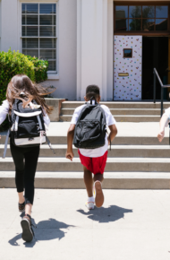 tre alunni delle medie entrano a scuola correndo